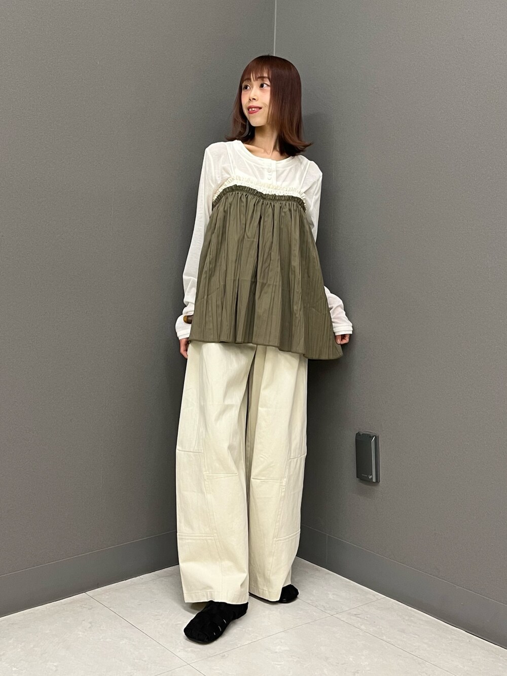 ホワイト系のカーディガン/ボレロ、グリーン系のその他トップス、ブラウン系のバックパック/リュックを着用したレディースの春コーディネートの2枚目の写真