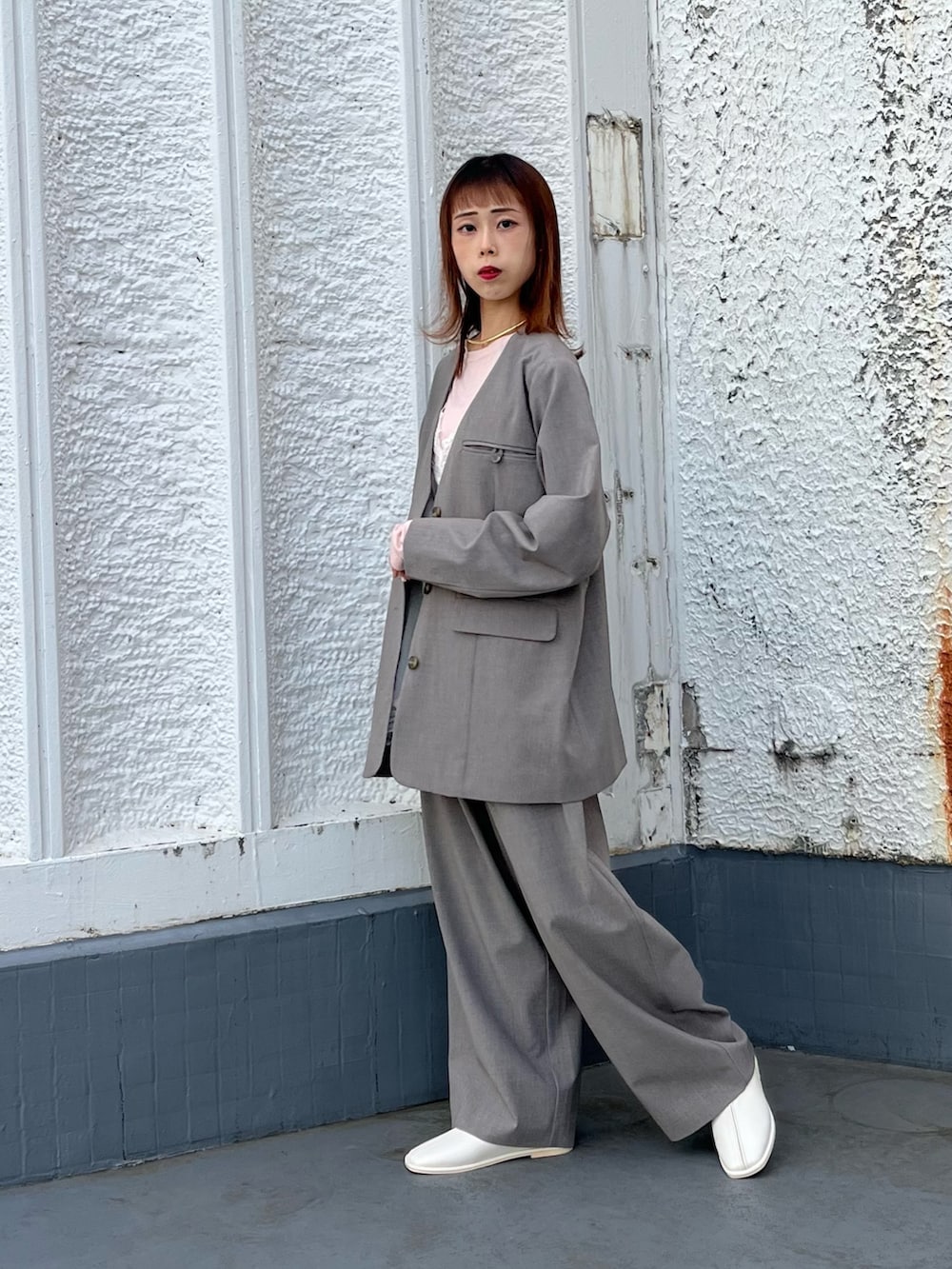 ブラウン系のTシャツ/カットソー、グレー系のノーカラージャケット、ホワイト系のキャミソールを着用したレディースの冬コーディネートの3枚目の写真