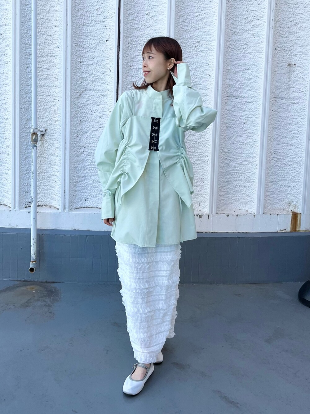 グリーン系のシャツ/ブラウス、ホワイト系のスカートを着用したレディースの冬コーディネートの2枚目の写真