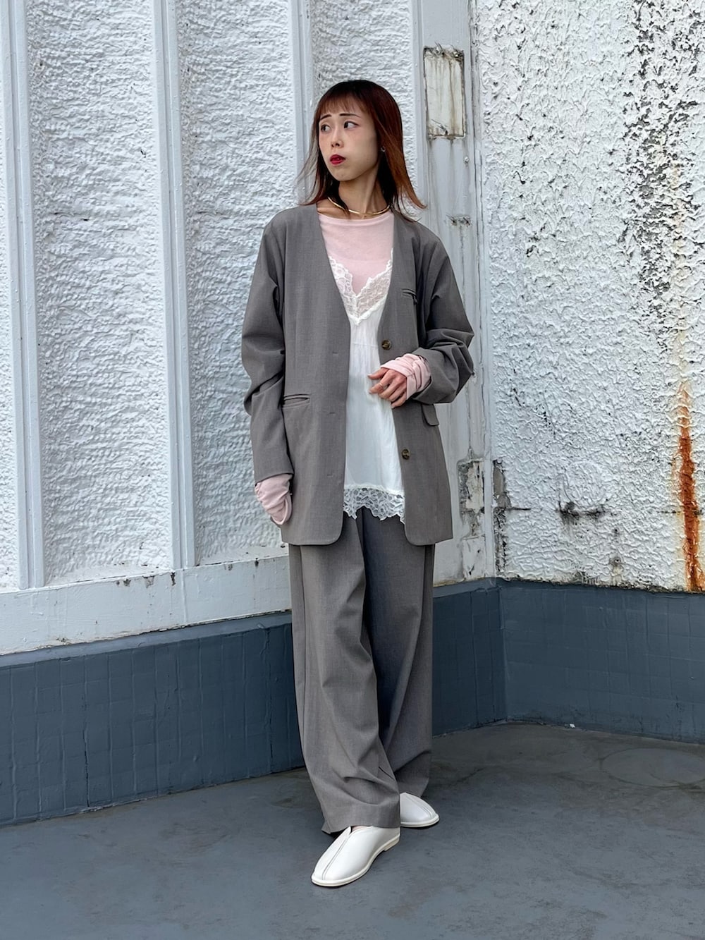 ブラウン系のTシャツ/カットソー、グレー系のノーカラージャケット、ホワイト系のキャミソールを着用したレディースの冬コーディネートの2枚目の写真