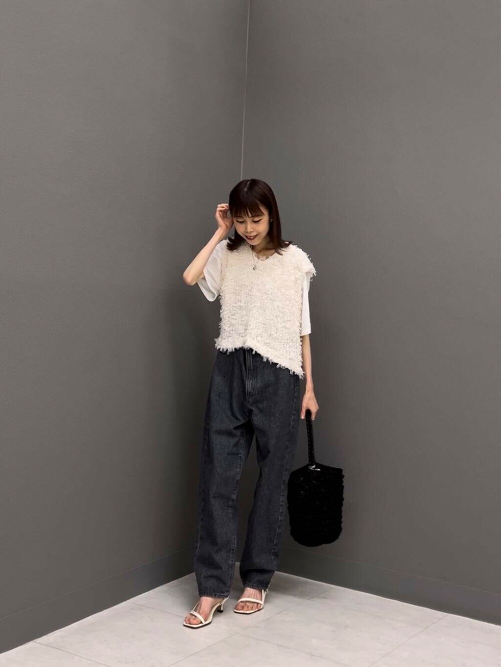 ホワイト系のTシャツ/カットソー、ブラック系のショルダーバッグ、ホワイト系のベストを着用したレディースの夏コーディネートの2枚目の写真