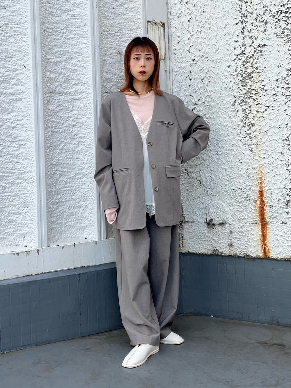 ブラウン系のTシャツ/カットソー、グレー系のノーカラージャケット、ホワイト系のキャミソールを着用したレディースの冬コーディネートの4枚目の写真