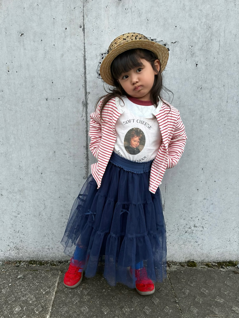 レッド系のカーディガン/ボレロ、ホワイト系のTシャツ/カットソー、ブルー系のスカートを着用したキッズの春コーディネートの2枚目の写真