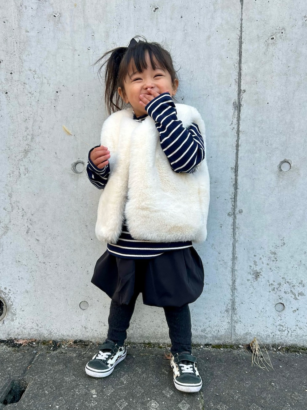 ブルー系のトップス、ブラック系のスカート、ブラック系のスニーカーを着用したキッズの冬コーディネートの2枚目の写真