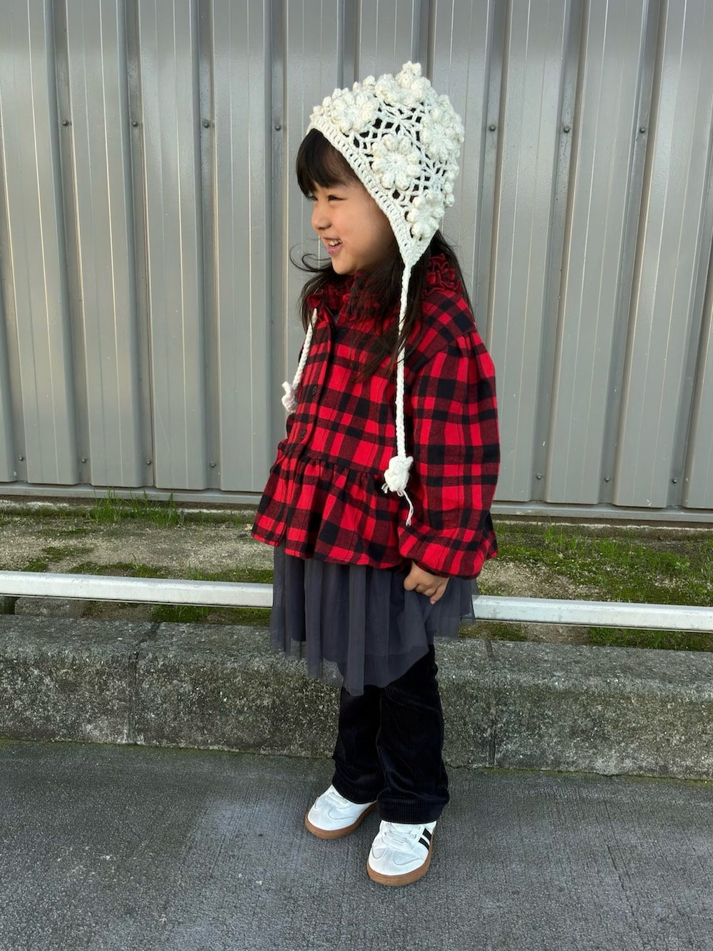 レッド系のシャツ/ブラウス、ブラック系のパンツ、ホワイト系の帽子を着用したキッズの冬コーディネートの2枚目の写真