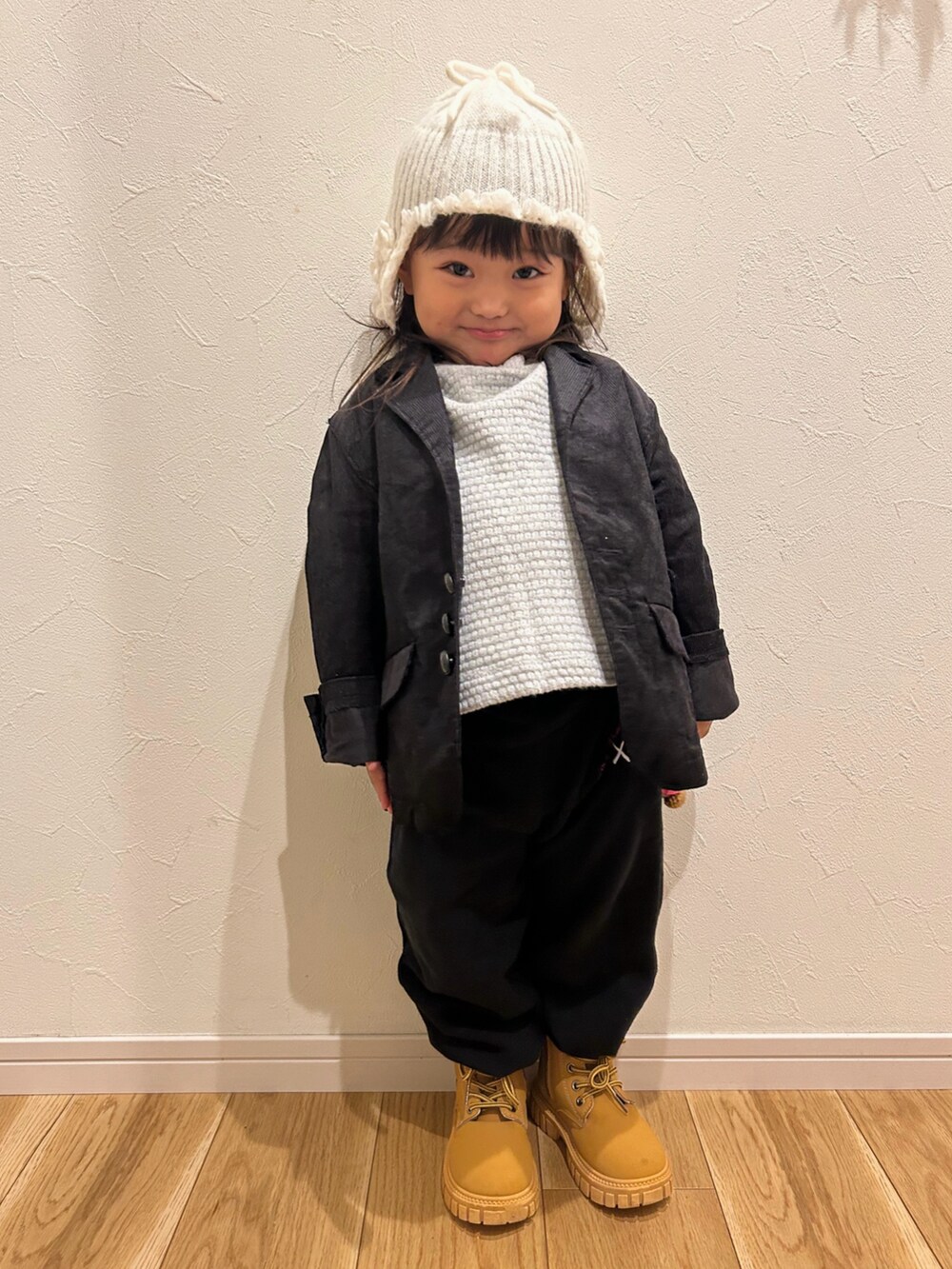 ブラック系のテーラードジャケット、ブラック系のスウェットパンツ、ベージュ系のスニーカーを着用したキッズの秋コーディネートの2枚目の写真