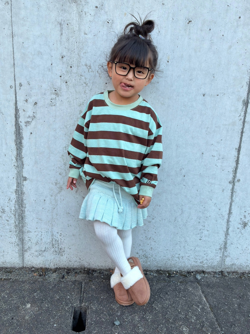 グリーン系のTシャツ/カットソー、ブルー系のスカート、ブラウン系のジャケット/アウターを着用したキッズの秋コーディネートの3枚目の写真