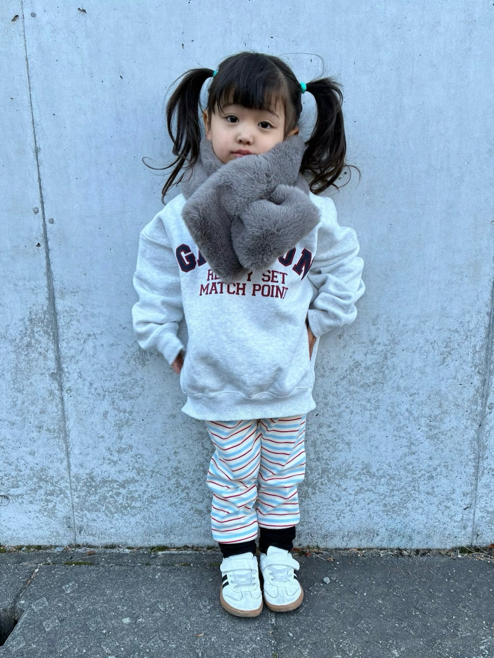 グレー系のスウェット、ベージュ系のマフラー、ブルー系のレギンス/スパッツを着用したキッズの冬コーディネートの2枚目の写真