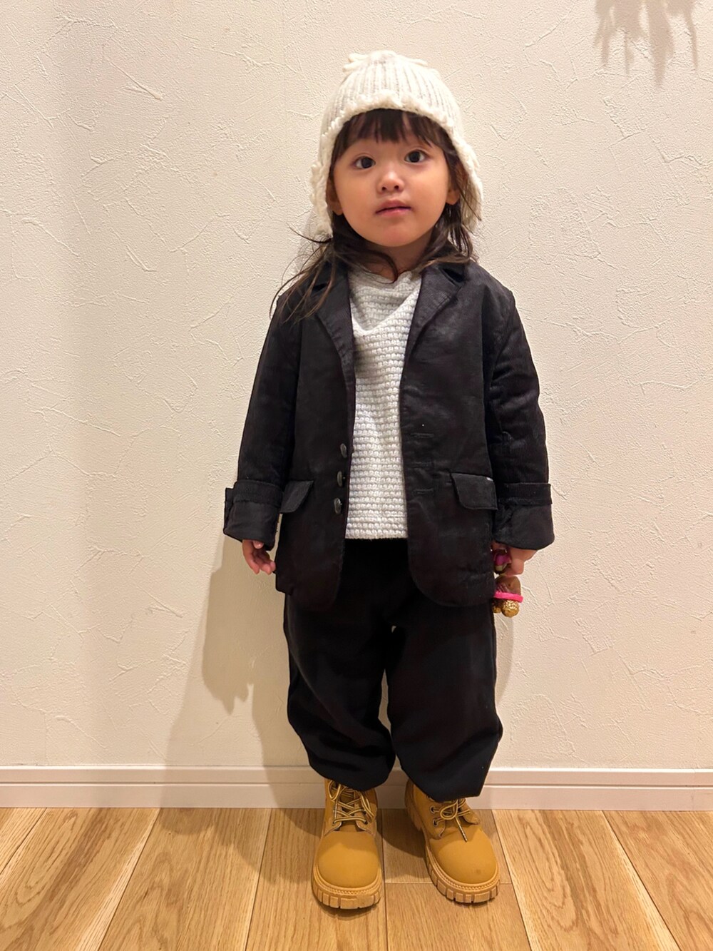 ブラック系のテーラードジャケット、ブラック系のスウェットパンツ、ベージュ系のスニーカーを着用したキッズの秋コーディネートの3枚目の写真