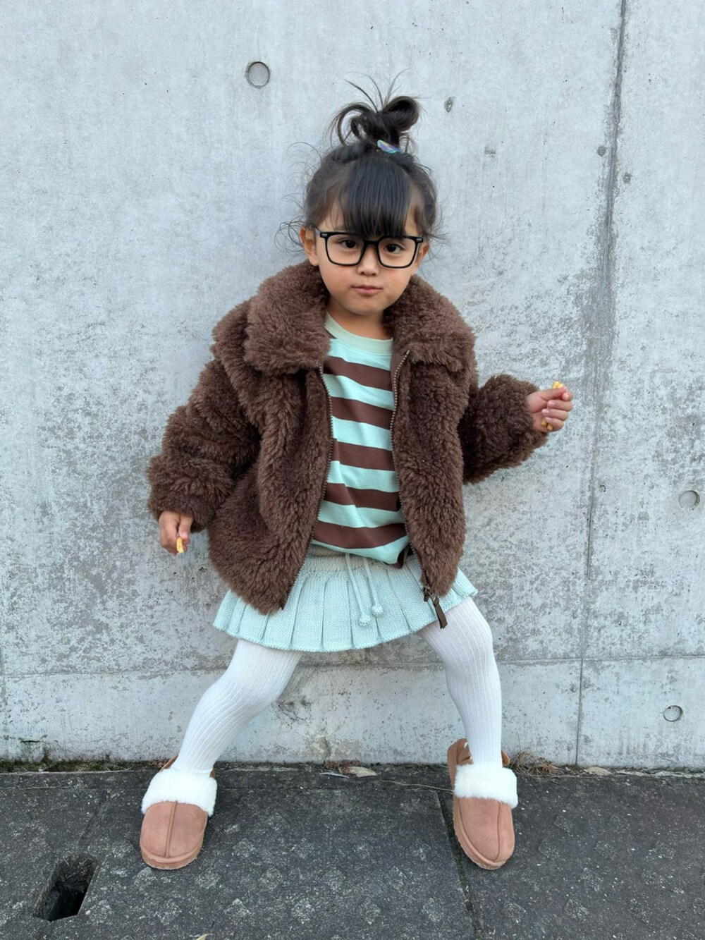 グリーン系のTシャツ/カットソー、ブルー系のスカート、ブラウン系のジャケット/アウターを着用したキッズの秋コーディネートの2枚目の写真