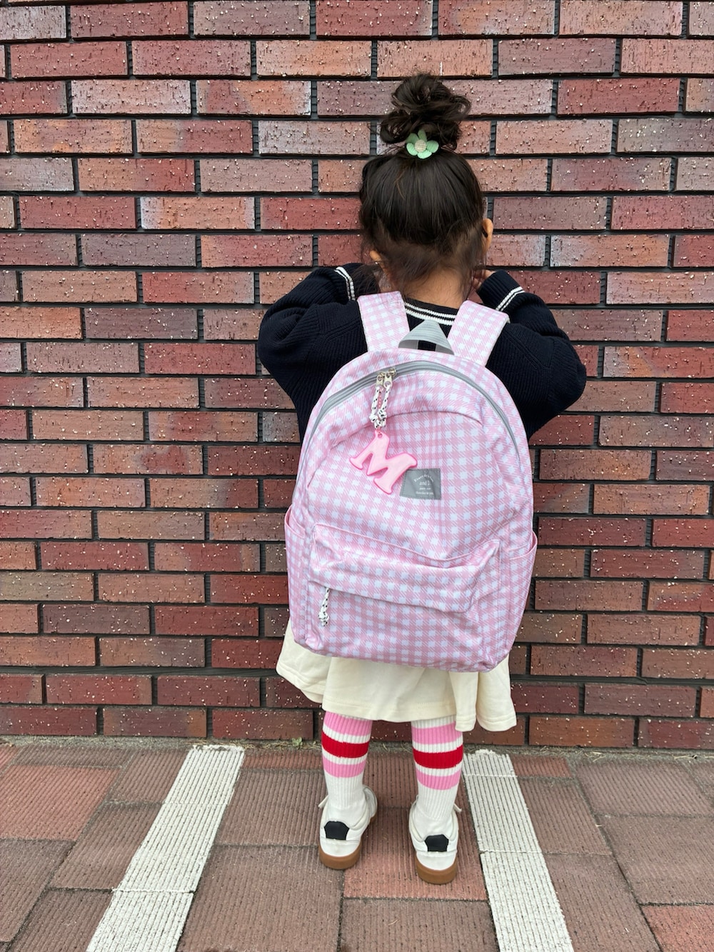 ブルー系のカーディガン/ボレロ、ベージュ系のワンピース、ピンク系のバックパック/リュックを着用したキッズの冬コーディネートの3枚目の写真