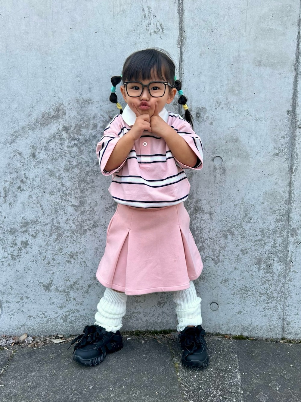 ピンク系のポロシャツ、ピンク系のスカート、ブラック系のスニーカーを着用したキッズの春コーディネートの2枚目の写真