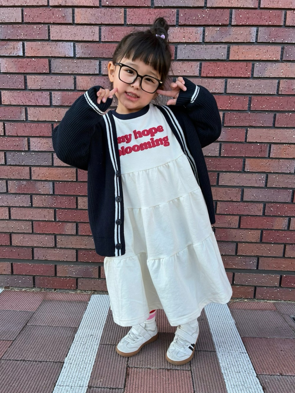 ブルー系のカーディガン/ボレロ、ベージュ系のワンピース、ピンク系のバックパック/リュックを着用したキッズの冬コーディネートの2枚目の写真