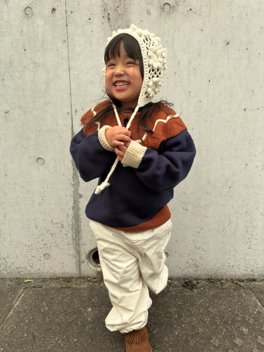 ブルー系のニット/セーター、ホワイト系のパンツ、ホワイト系の帽子を着用したキッズの冬コーディネートの2枚目の写真