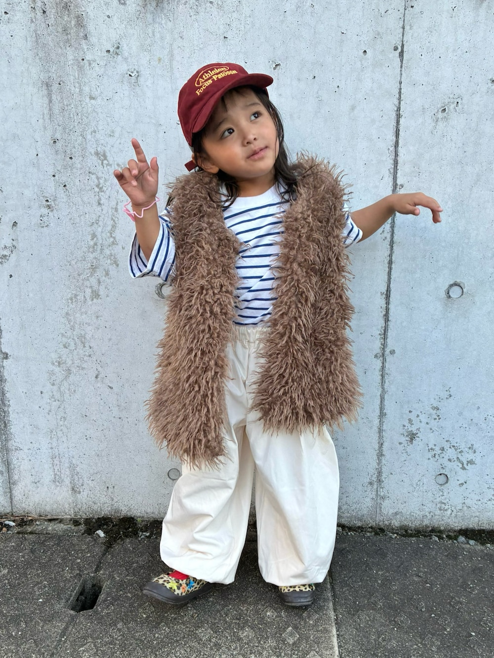 ベージュ系のベスト、ホワイト系のTシャツ/カットソー、ホワイト系のパンツを着用したキッズの秋コーディネートの2枚目の写真