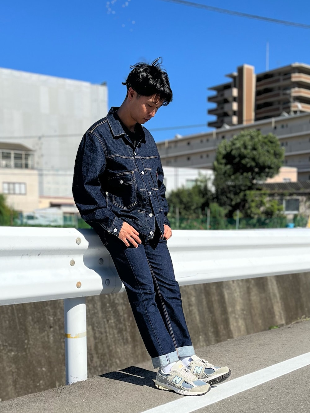 ブルー系のデニムジャケット、ブルー系のデニムパンツ、グレー系のスニーカーを着用したメンズの秋コーディネートの3枚目の写真