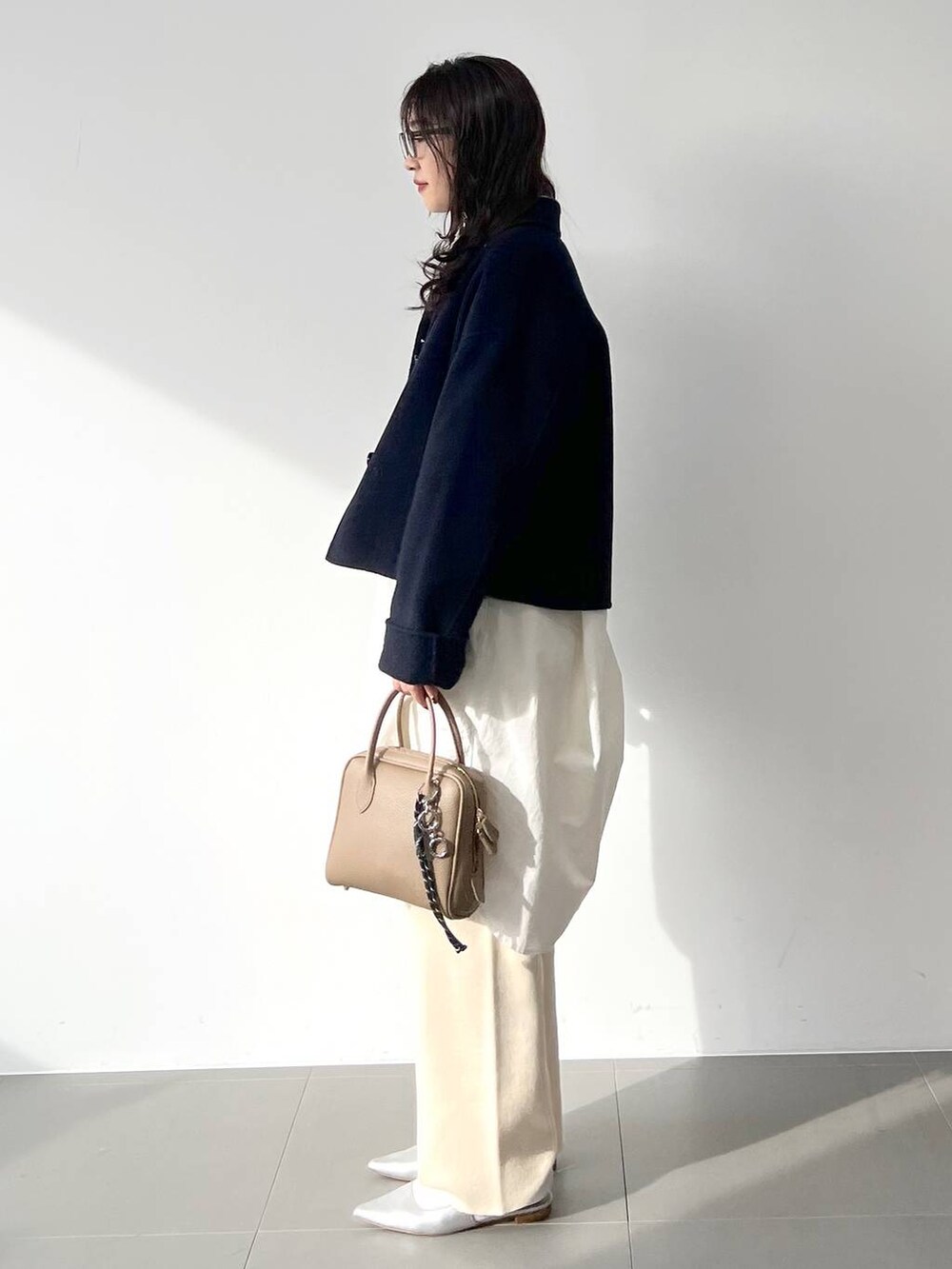 ホワイト系のその他パンツ、ホワイト系のシャツワンピース、シルバー系のパンプスを着用したレディースの冬コーディネートの6枚目の写真