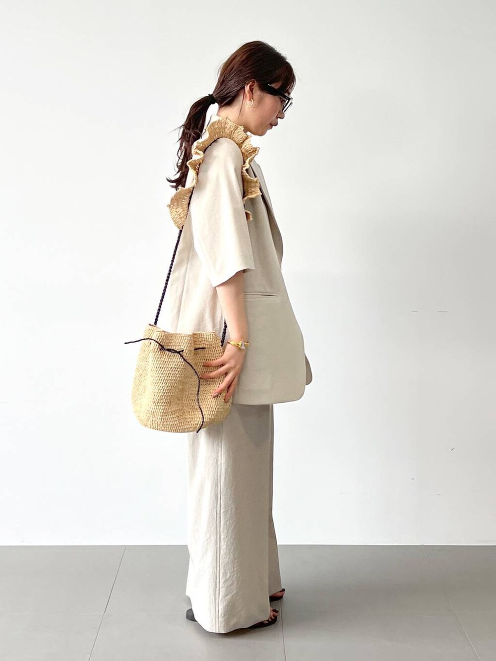 レッド系のサンダル、ベージュ系のテーラードジャケット、ベージュ系のその他パンツを着用したレディースの春コーディネートの5枚目の写真