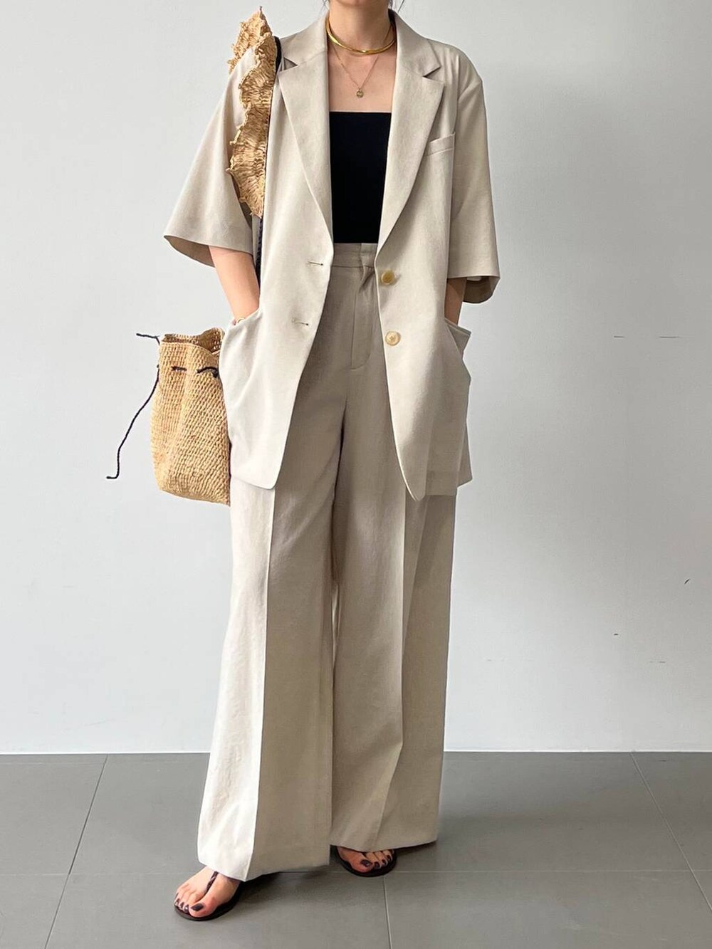 レッド系のサンダル、ベージュ系のテーラードジャケット、ベージュ系のその他パンツを着用したレディースの春コーディネートの8枚目の写真