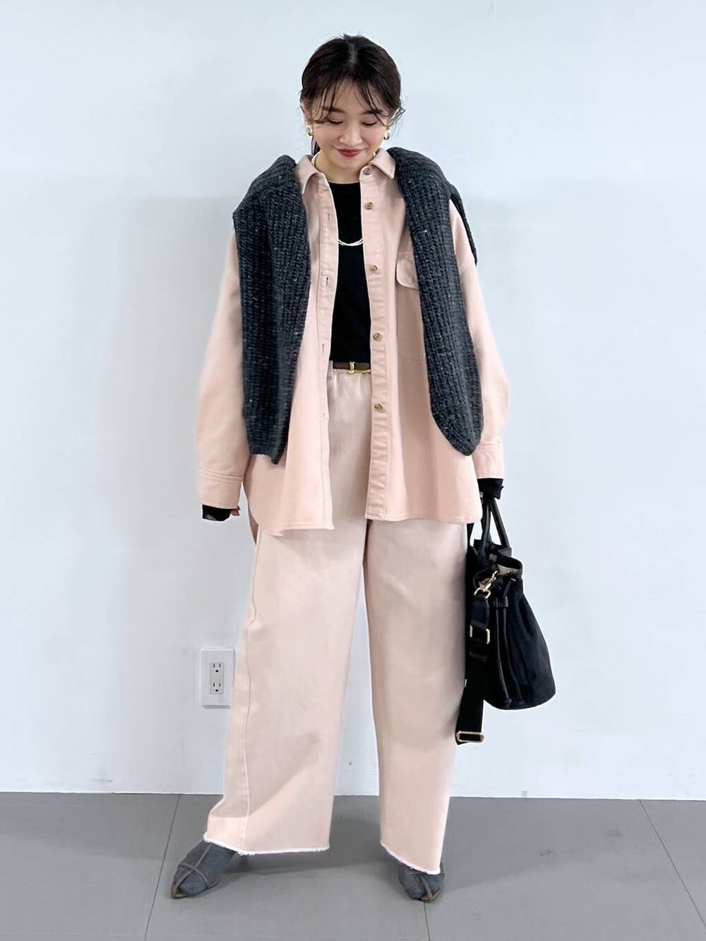ピンク系のデニムパンツ、ベージュ系のサンダル、グレー系のニット/セーターを着用したレディースの冬コーディネートの3枚目の写真