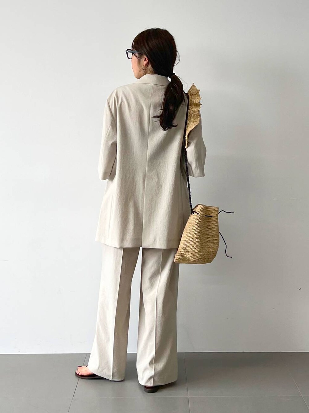 レッド系のサンダル、ベージュ系のテーラードジャケット、ベージュ系のその他パンツを着用したレディースの春コーディネートの7枚目の写真