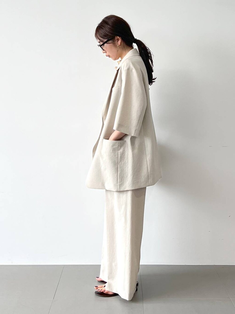 レッド系のサンダル、ベージュ系のテーラードジャケット、ベージュ系のその他パンツを着用したレディースの春コーディネートの6枚目の写真