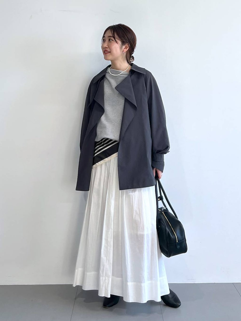 ホワイト系のスカート、グレー系のスウェット、グレー系のトレンチコートを着用したレディースの冬コーディネートの3枚目の写真