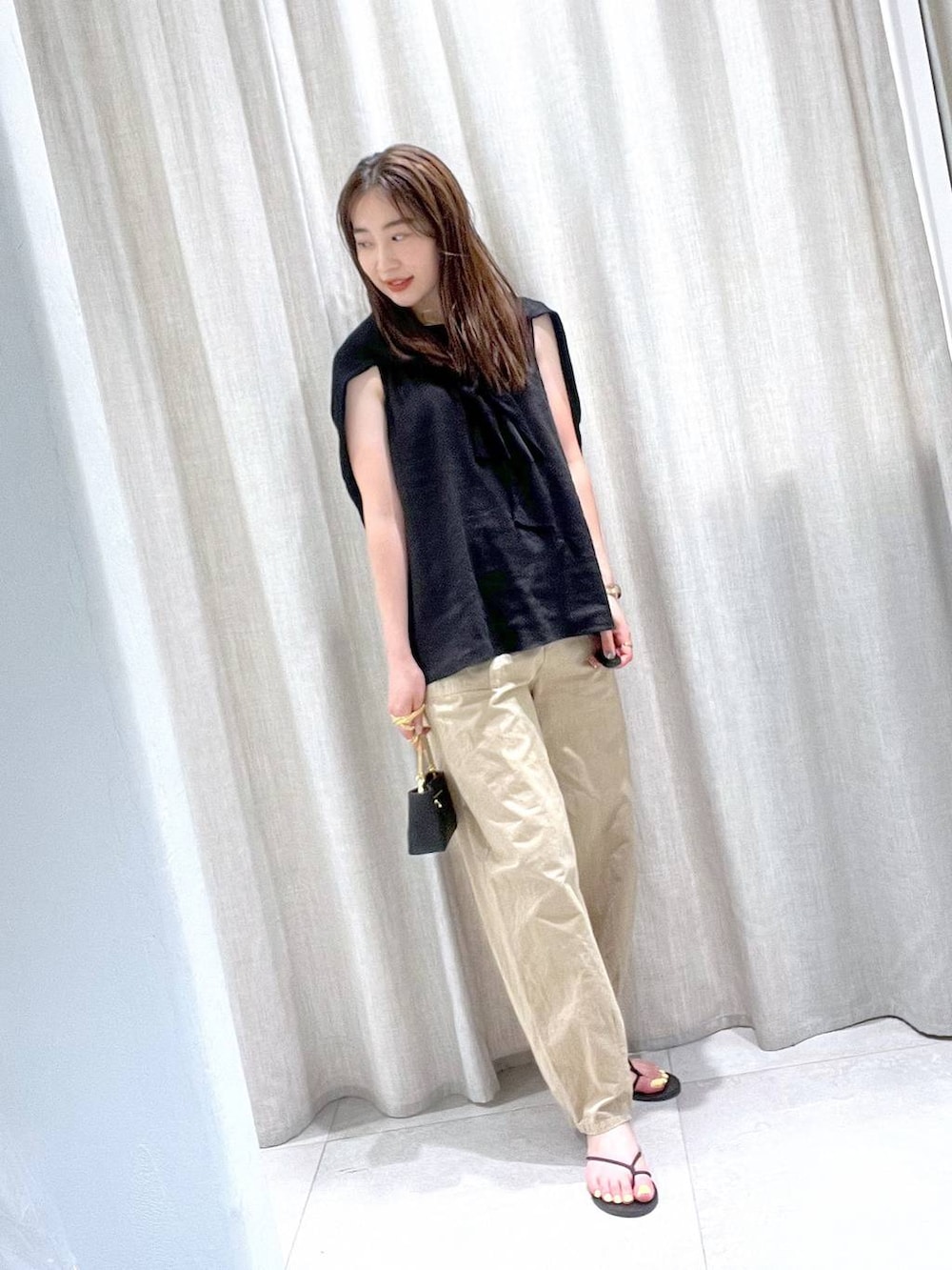 ブラック系のカーディガン/ボレロ、ベージュ系のその他パンツ、ブラック系のサンダルを着用したレディースの夏コーディネートの2枚目の写真