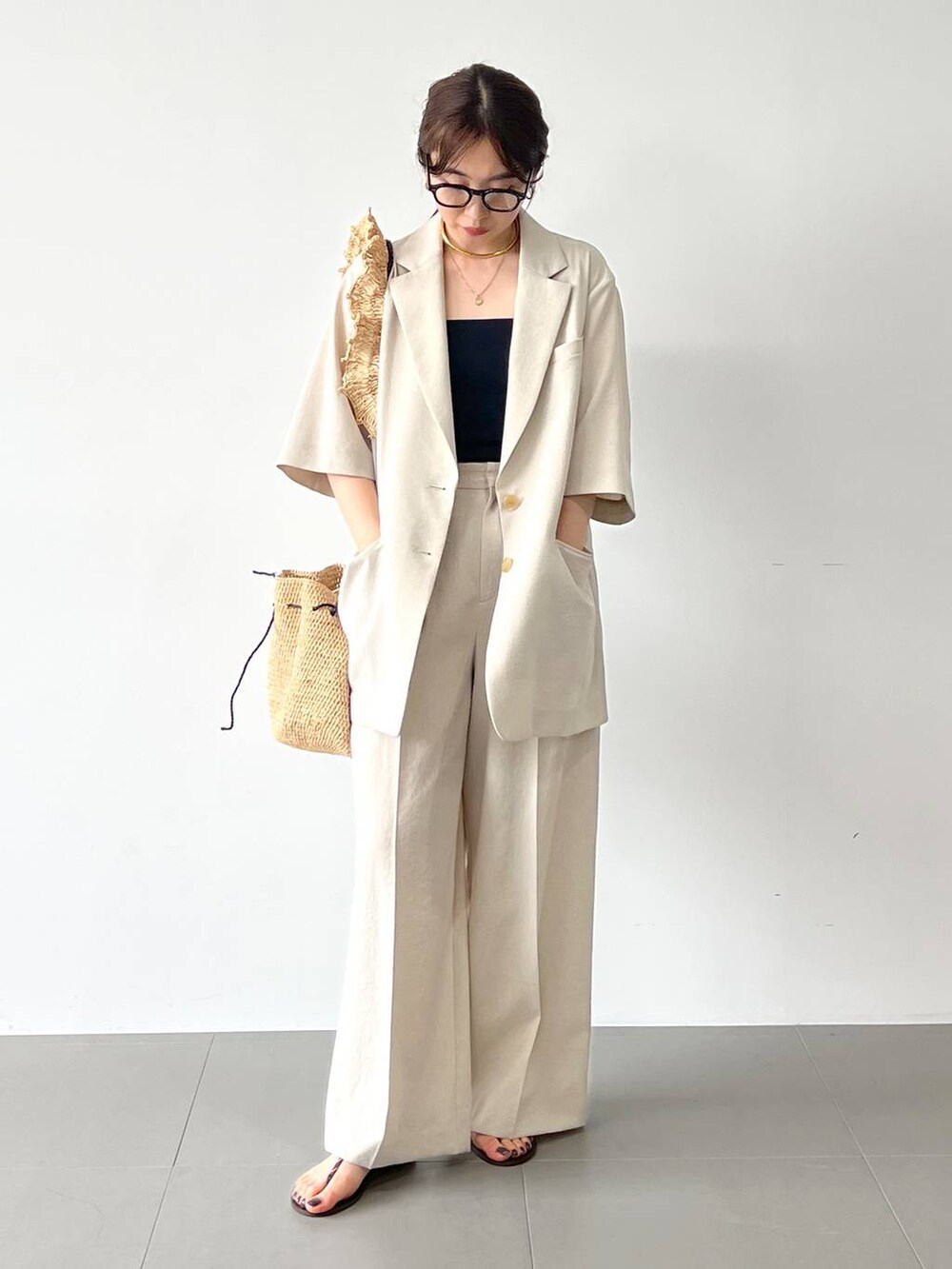 レッド系のサンダル、ベージュ系のテーラードジャケット、ベージュ系のその他パンツを着用したレディースの春コーディネートの3枚目の写真