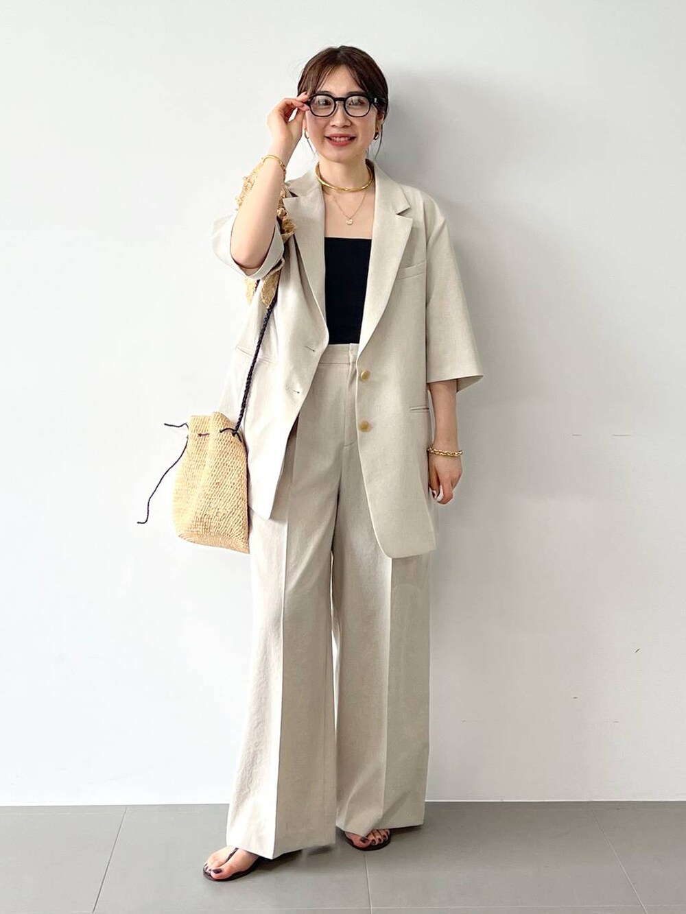 レッド系のサンダル、ベージュ系のテーラードジャケット、ベージュ系のその他パンツを着用したレディースの春コーディネートの2枚目の写真