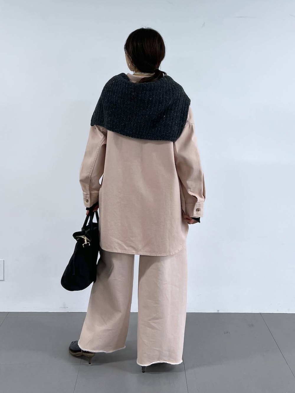 ピンク系のデニムパンツ、ベージュ系のサンダル、グレー系のニット/セーターを着用したレディースの冬コーディネートの6枚目の写真