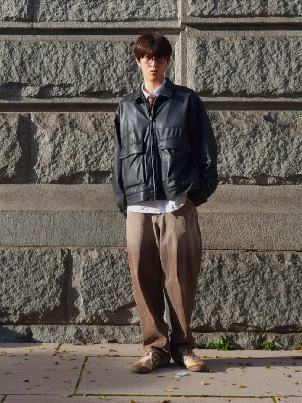 ブラック系のブルゾン、ホワイト系のシャツ/ブラウス、ブラウン系のデニムパンツを着用したメンズの秋コーディネートの2枚目の写真