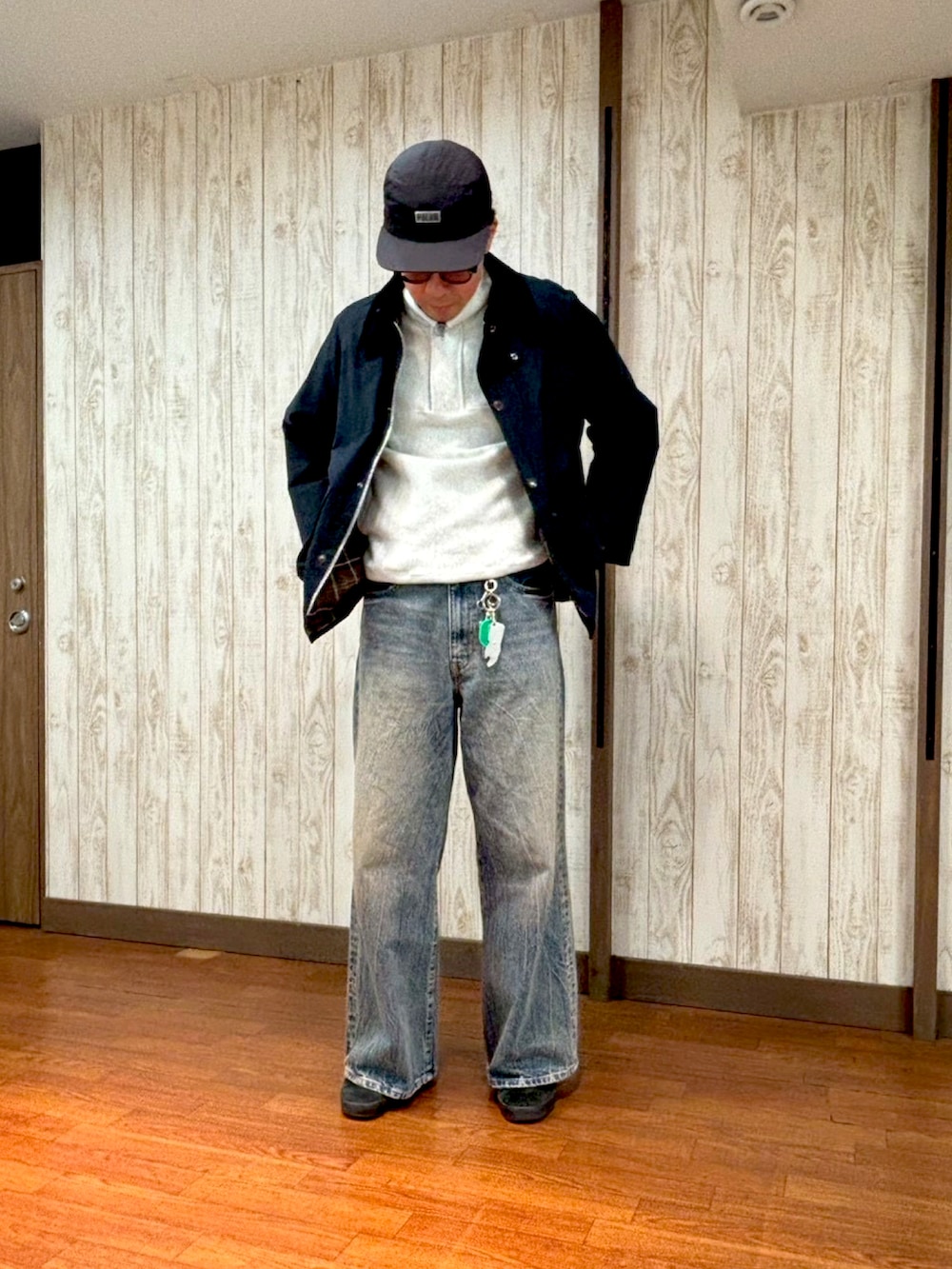 ホワイト系のスウェット、ブルー系のデニムパンツ、ブラック系のスニーカーを着用したメンズの冬コーディネートの3枚目の写真