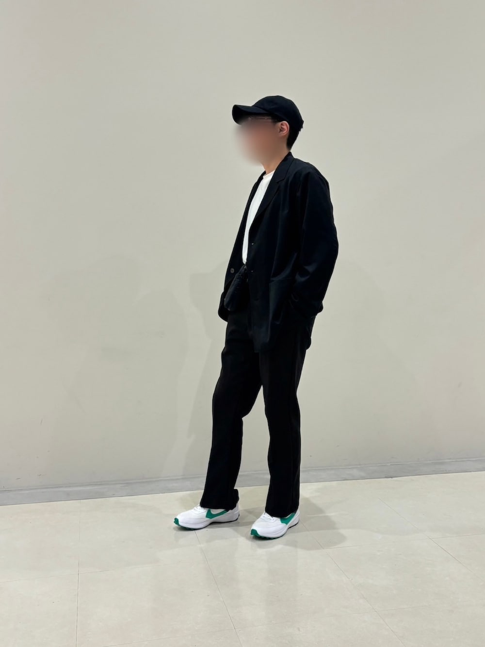 ブラック系のスラックス、ブラック系のショルダーバッグ、ブラック系のテーラードジャケットを着用したメンズの秋コーディネートの5枚目の写真