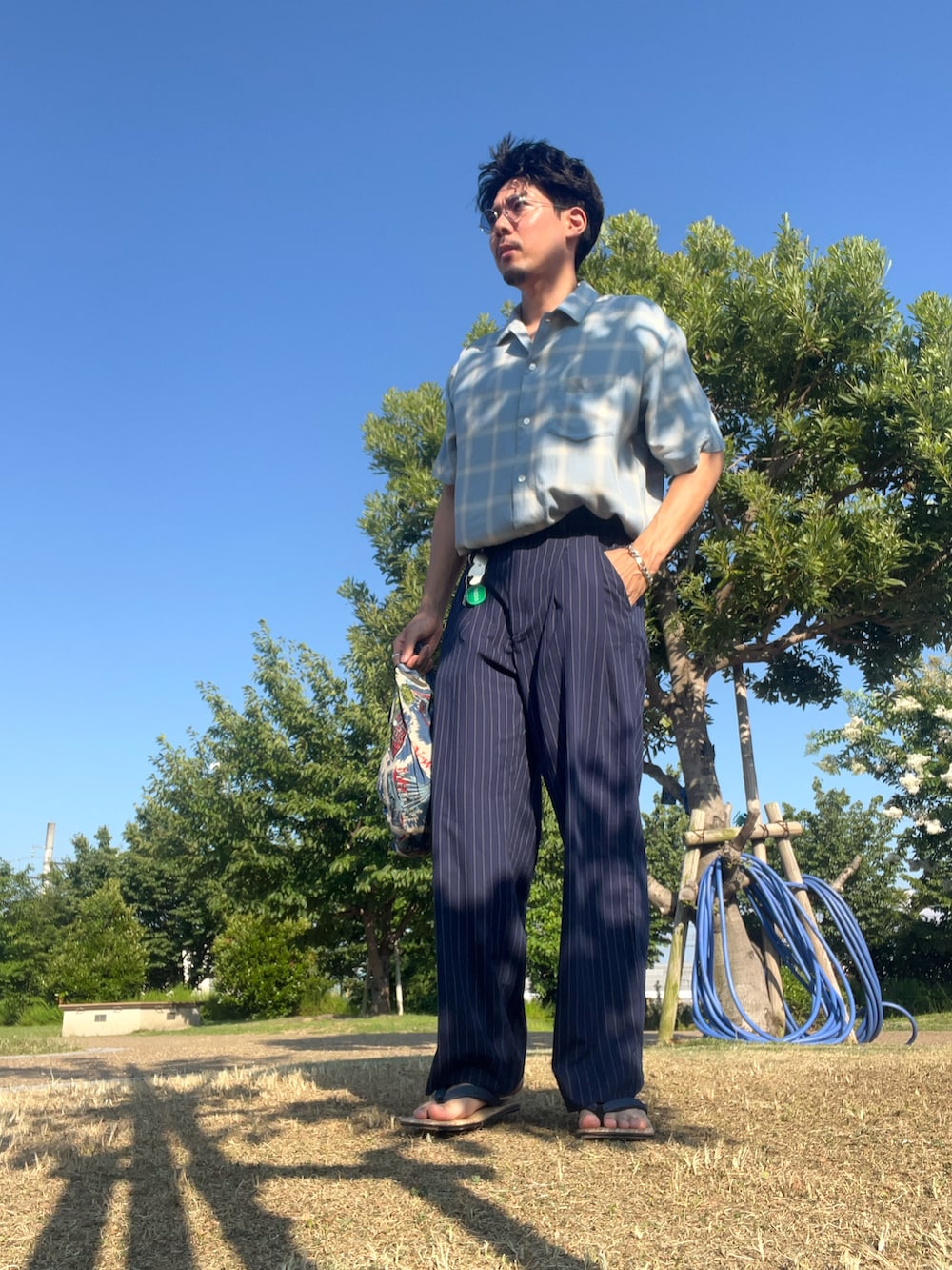 ブルー系のシャツ/ブラウス、ブルー系のスラックス、シルバー系のキーホルダーを着用したメンズの夏コーディネートの3枚目の写真