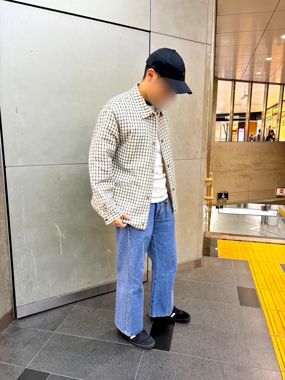 ホワイト系のブルゾン、ブラック系のスニーカー、ブルー系のデニムパンツを着用したメンズの秋コーディネートの3枚目の写真