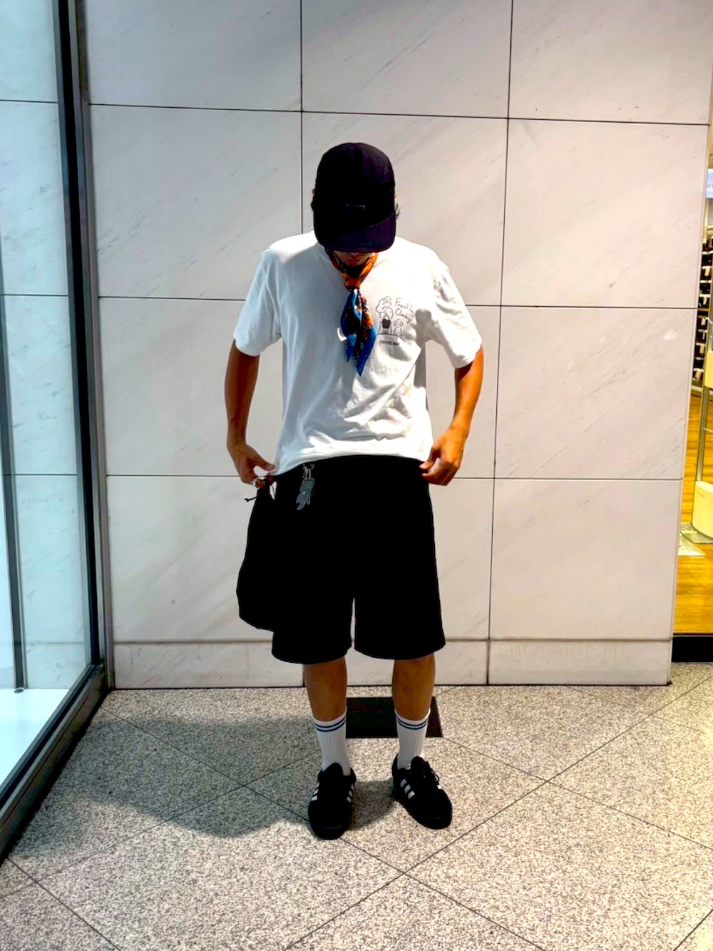ブラック系のスニーカー、ホワイト系のTシャツ/カットソー、ブラック系のパンツを着用したメンズの夏コーディネートの2枚目の写真