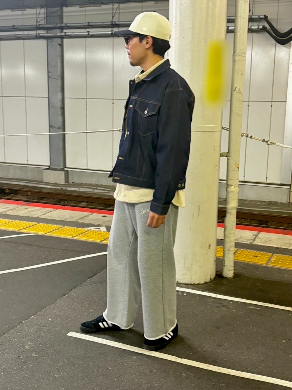 ブルー系のデニムジャケット、グレー系のスウェットパンツ、ブラック系のスニーカーを着用したメンズの冬コーディネートの2枚目の写真