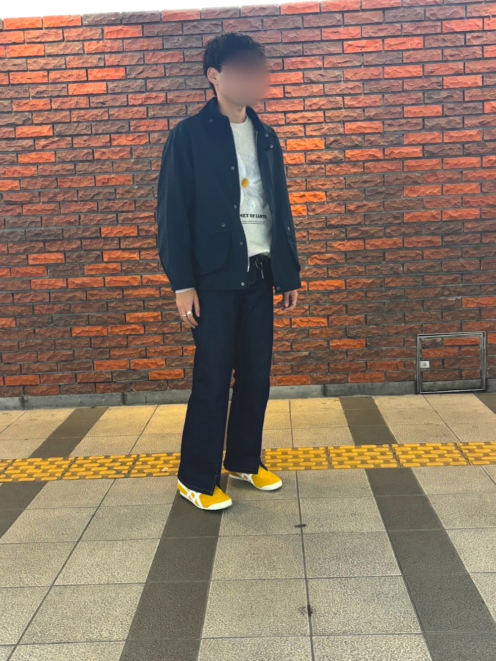 ホワイト系のスウェット、イエロー系のスリッポン、ブルー系のデニムパンツを着用したメンズの冬コーディネートの2枚目の写真