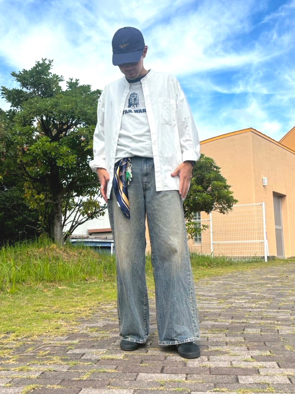 ホワイト系のシャツ/ブラウス、ブラック系のスニーカー、ブルー系のデニムパンツを着用したメンズの秋コーディネートの2枚目の写真