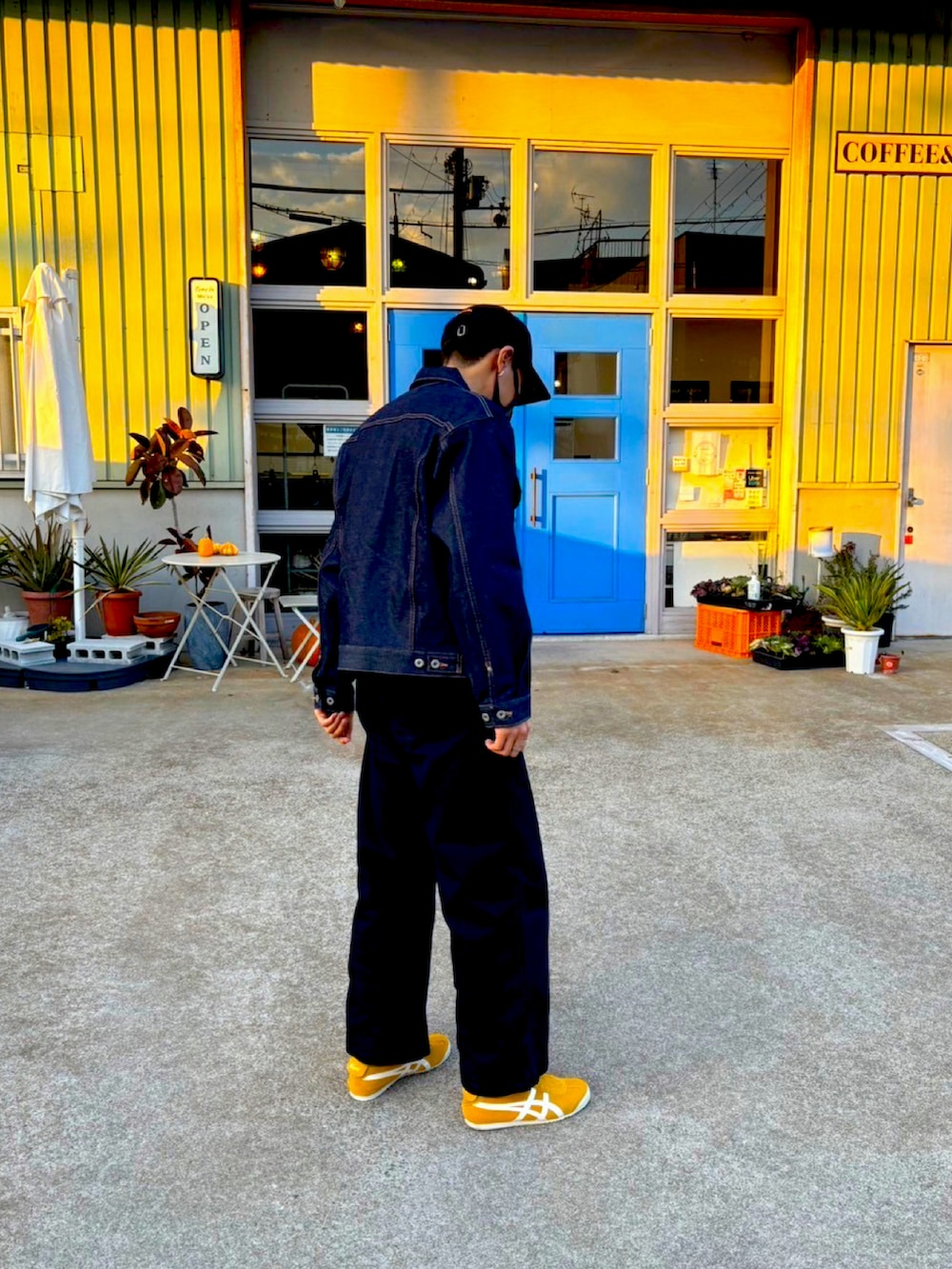 ブルー系のデニムジャケット、イエロー系のスリッポン、ブラック系のその他パンツを着用したメンズの冬コーディネートの3枚目の写真