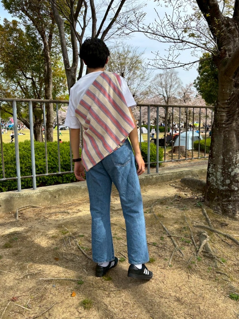 「春めき満開コーデ、たすき掛け、さし色、春服、春色、スニーカー、adidas、デニム、Tシャツ、タックイン、白Tシャツ、アクセサリー、カジュアル、柄シャツ、ピクニック」｜「adidasのプイグ インドア / Puig Indoor / アディダスオリジナルス adidas Originals（スニーカー、ブラック系）」を使った、Ryさん（メンズ・175cm）の春コーディネートの3枚目の写真