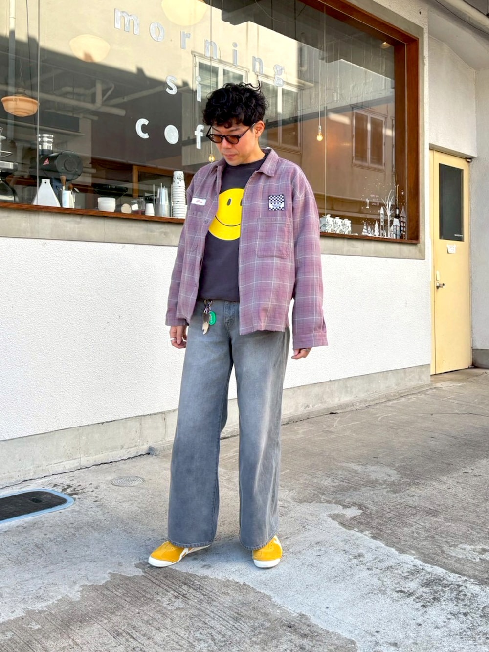 グレー系のデニムパンツ、イエロー系のスリッポン、ブラック系のスウェットを着用したメンズの冬コーディネートの3枚目の写真