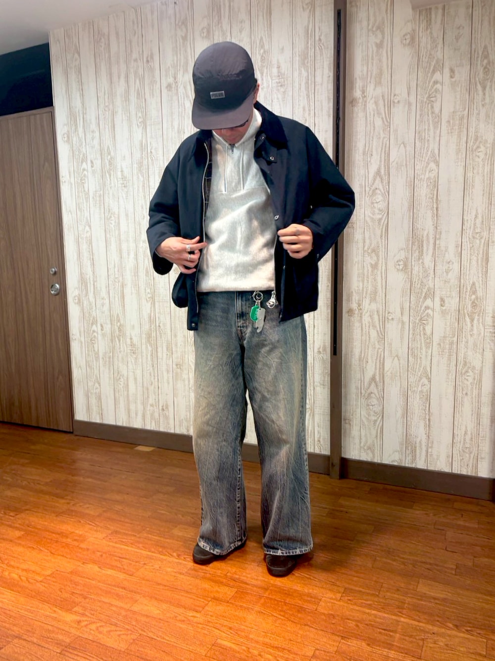 ホワイト系のスウェット、ブルー系のデニムパンツ、ブラック系のスニーカーを着用したメンズの冬コーディネートの2枚目の写真