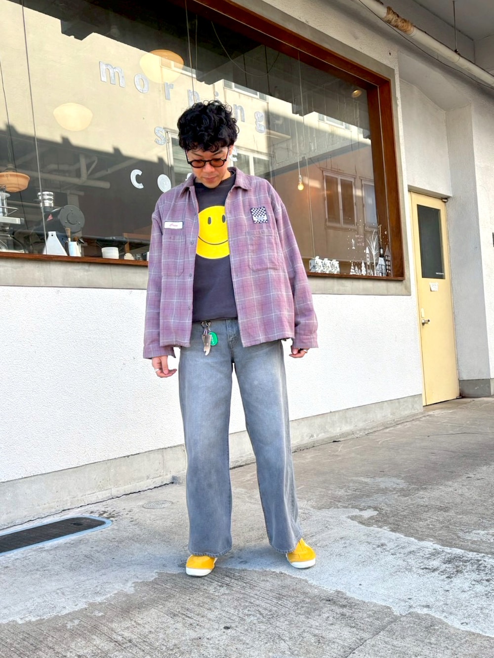 グレー系のデニムパンツ、イエロー系のスリッポン、ブラック系のスウェットを着用したメンズの冬コーディネートの2枚目の写真