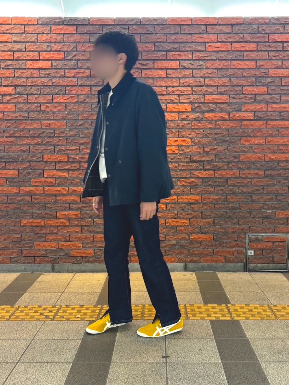 ホワイト系のスウェット、イエロー系のスリッポン、ブルー系のデニムパンツを着用したメンズの冬コーディネートの5枚目の写真