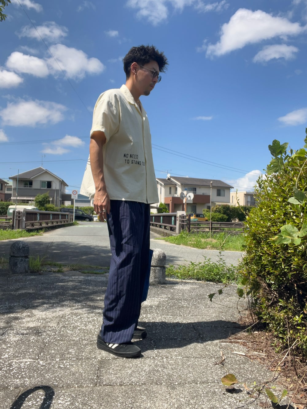ベージュ系のシャツ/ブラウス、ブルー系のスラックスを着用したメンズの夏コーディネートの2枚目の写真
