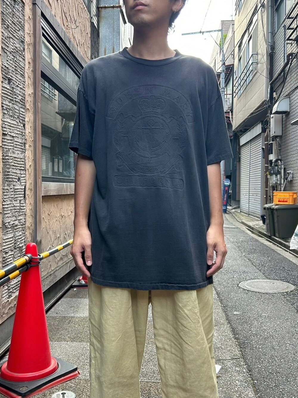 ブラック系のTシャツ/カットソー、イエロー系のパンツ、ブラック系のスニーカーを着用したメンズの夏コーディネートの2枚目の写真