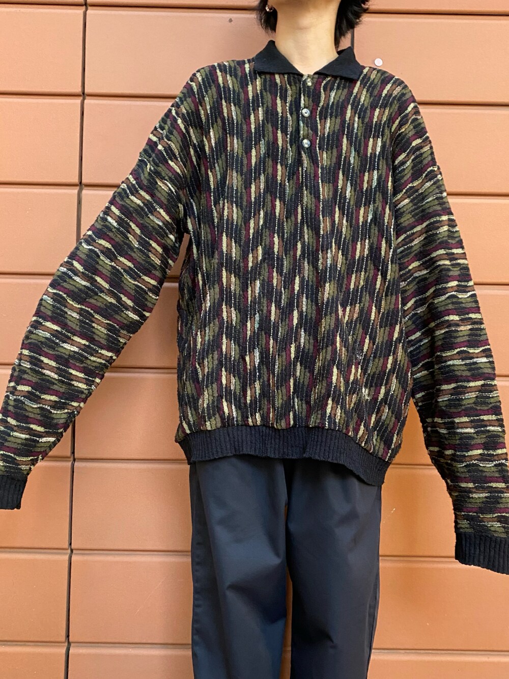 ブラック系のニット/セーター、ブラック系のスニーカーを着用したメンズの冬コーディネートの2枚目の写真