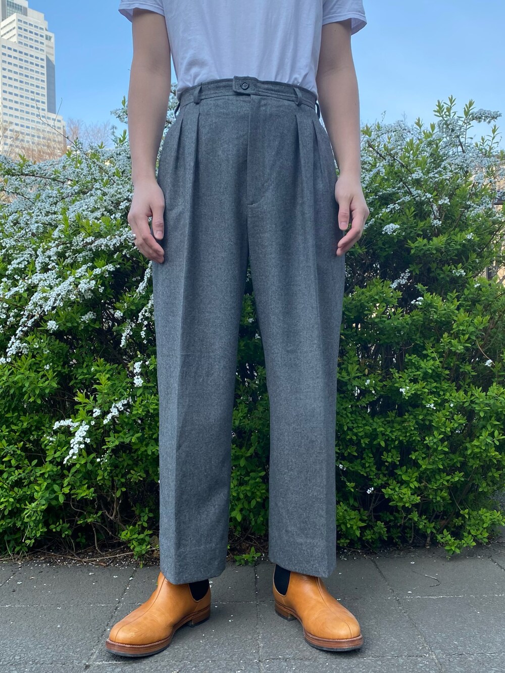 グリーン系のカーディガン/ボレロ、グレー系のスラックス、ブラウン系のシューズを着用したメンズの春コーディネートの2枚目の写真